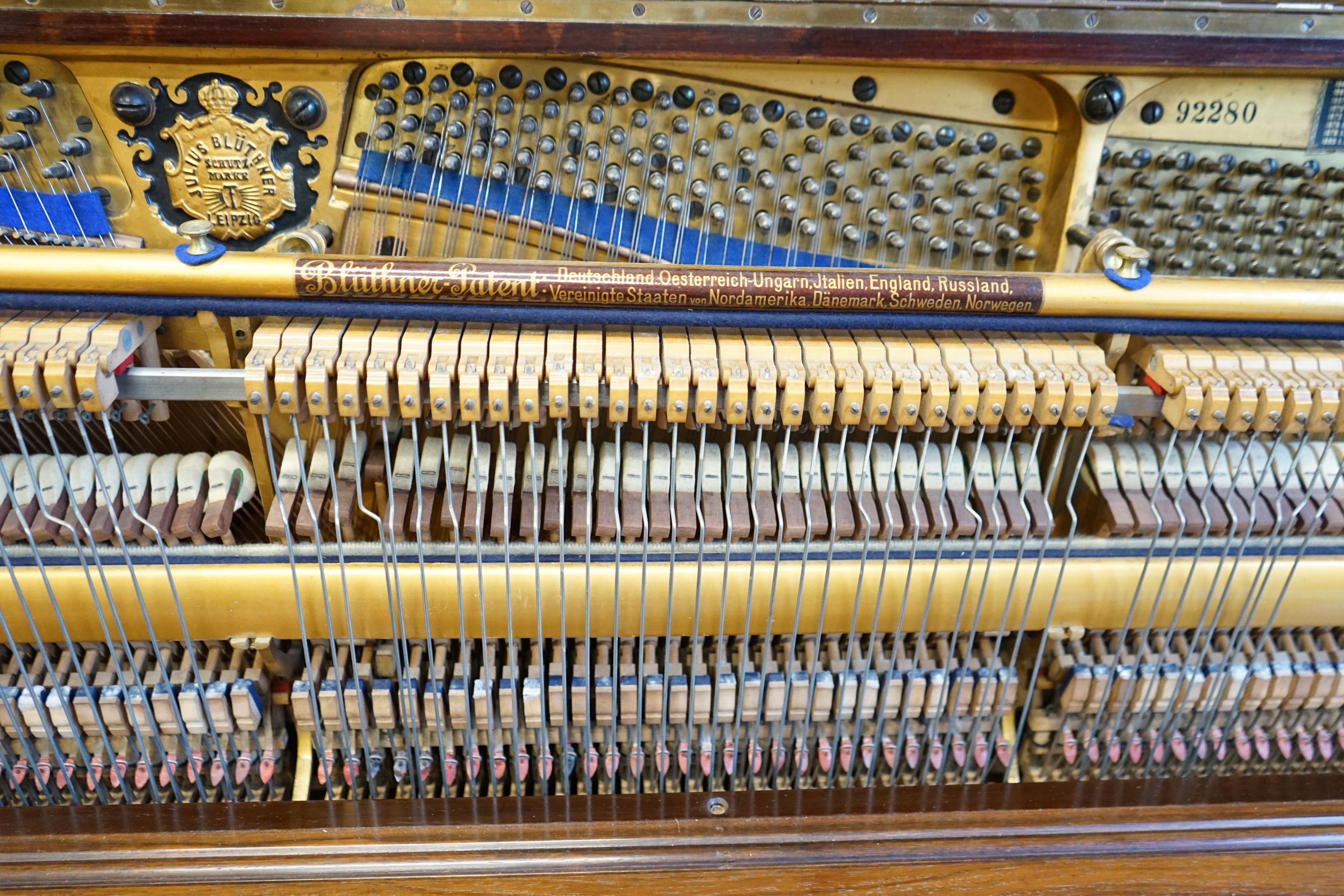 An early 20th century walnut cased Bluthner upright piano, Serial Number 92280